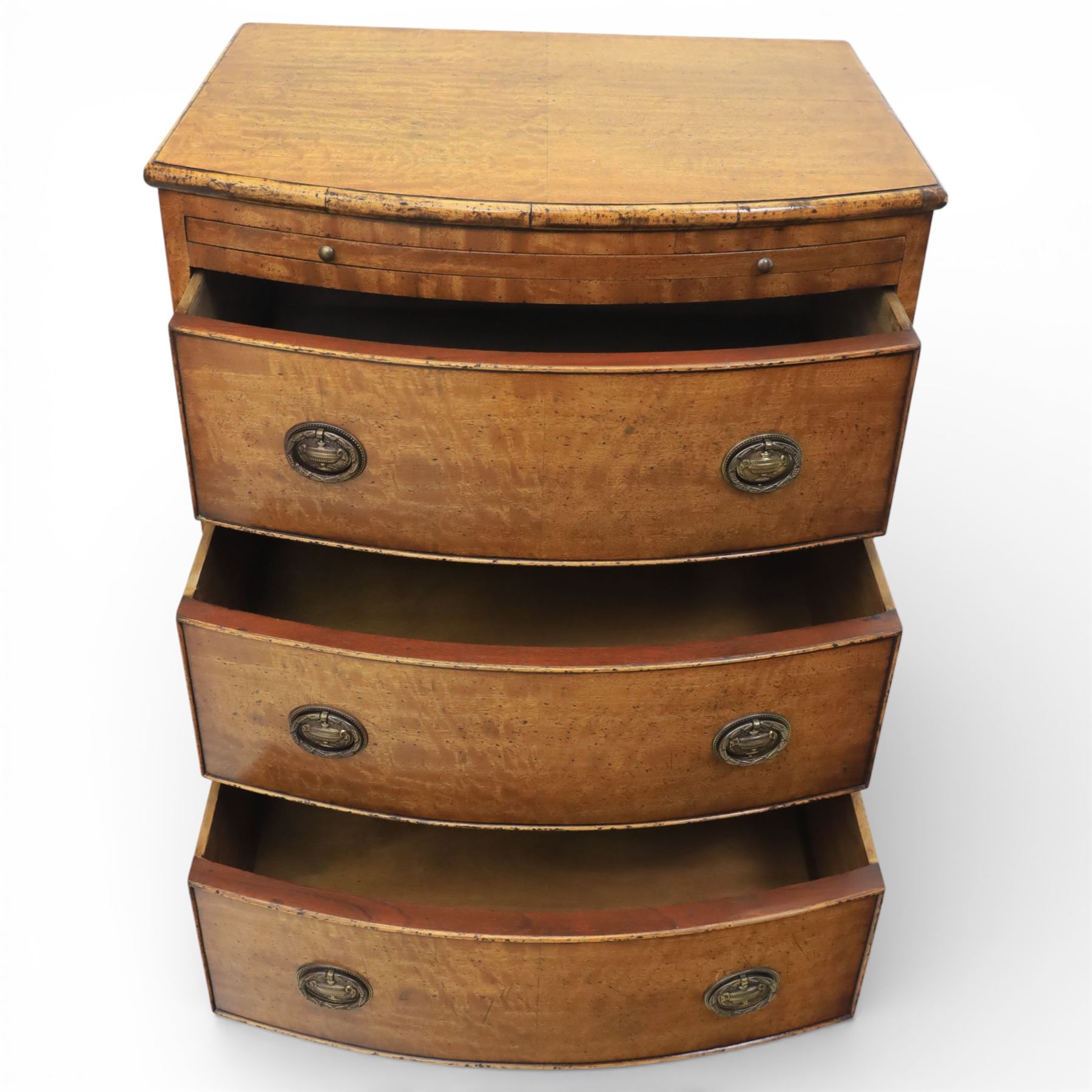 Georgian design bow front chest in figured walnut veneers, with moulded top over a pull-out brushing slide and three long drawers fitted with oval brass drop handles, raised upon swept bracket feet