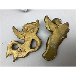 Pair of painted plaster wall brackets, each with a female mask support, her face bronzed with gilt hair and crescent, green acanthus leaves on black ground, L25cm, together with quantity of gilt cherub wall ornaments etc