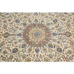 Central Persian Nain hand-knotted carpet, ivory field with central radiating medallion with pendants, issuing an all-over design of scrolling vines, palmettes, and floral sprays within confirming spandrels, framed a complimentary foliate border flanked by multiple guard stripes, with cotton fringe ends 