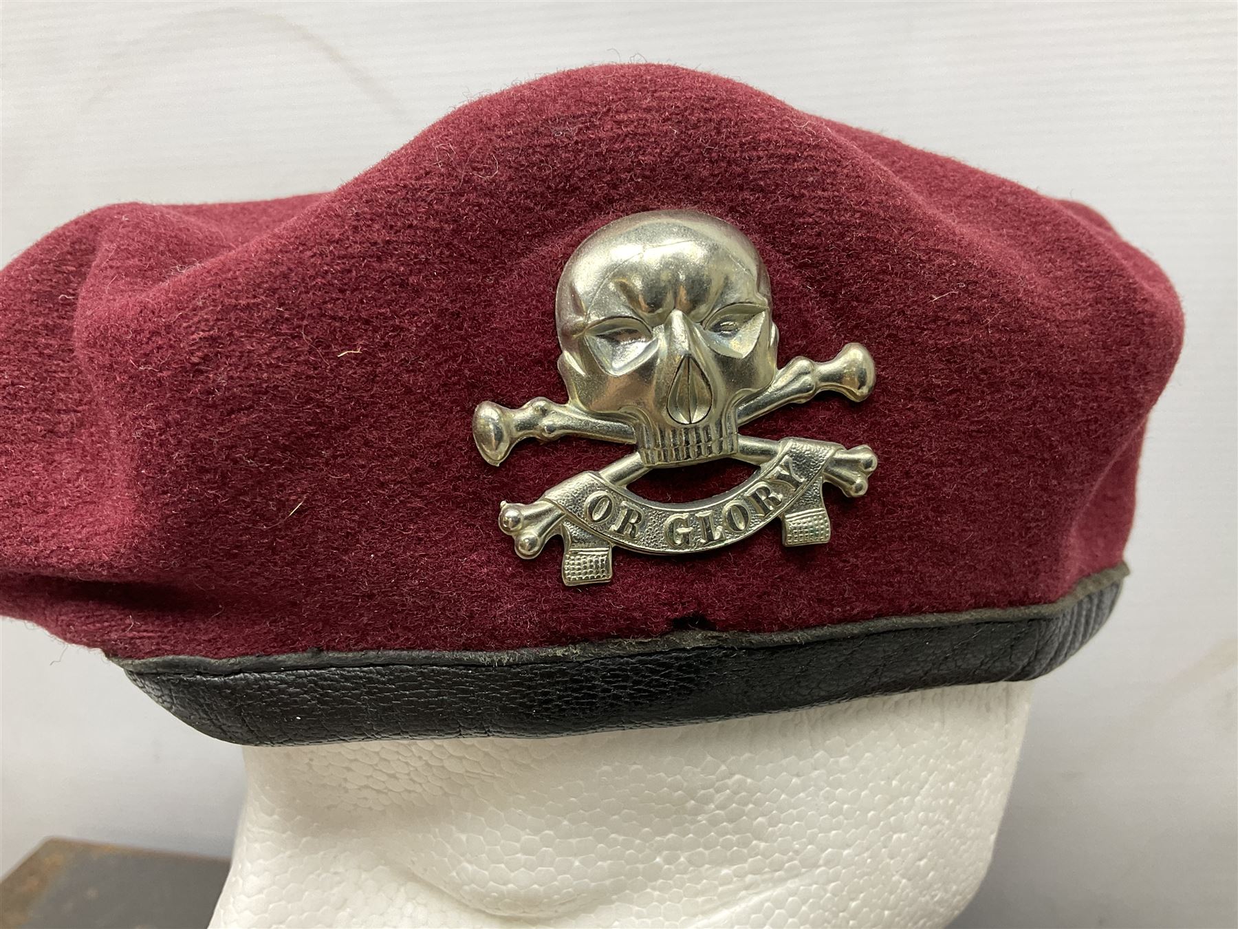 Assorted militaria including ten leather or canvas cartridge and other belts, maroon beret with 17th Lancers cap badge, modern bullet mould, leather and brass shot flask, two knives, shell cases, boomerang etc; in tin deed box