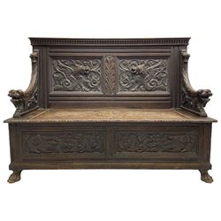 19th century oak hall bench, dentil cresting rail over moulded frame with panelled back carved with fire-breathing mythical beasts and central acanthus leaf motif, scroll carved down-sweeping arms carved with grotesque masks with scrolled foliage and shells, hinged box seat carved with scrolling foliage over panelled front with further carved foliage decoration, on paw carved front feet 