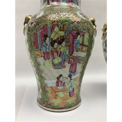 Pair of 19th century Chinese Famille Rose vases and covers, each of baluster form with twin gilt lion mask ring handles to shoulders, the flattened domed covers with gilt temple lion finials, each decorated with alternating reserves of bijin and attendants, and birds and butterflies amongst blossoming peonies, against a gilt ground profusely decorated with stylised scrolls, H32.5cm