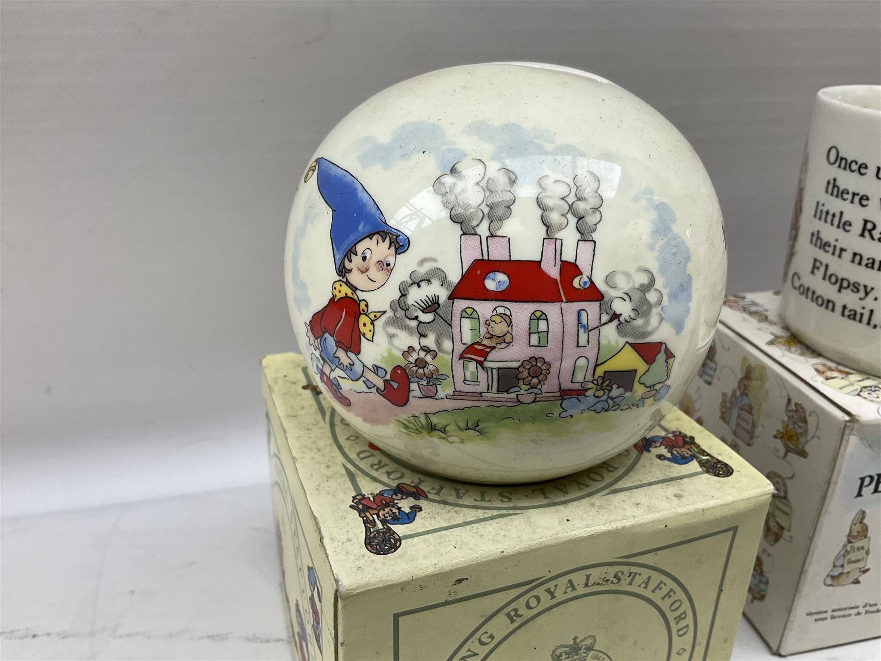 Royal Doulton Bunnykins nursery set in box and two cups, together with two Wedgwood Peter Rabbit mugs and Royal Staffordshire Noddy money box and cup (7)