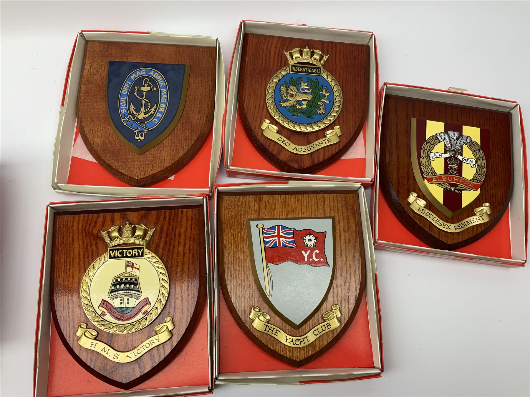 Various Navy wooden heraldic shields each with hand painted raised shield, including HMS Indefatigable, HMS Nelson,  HMS Victory etc, ten in total.  