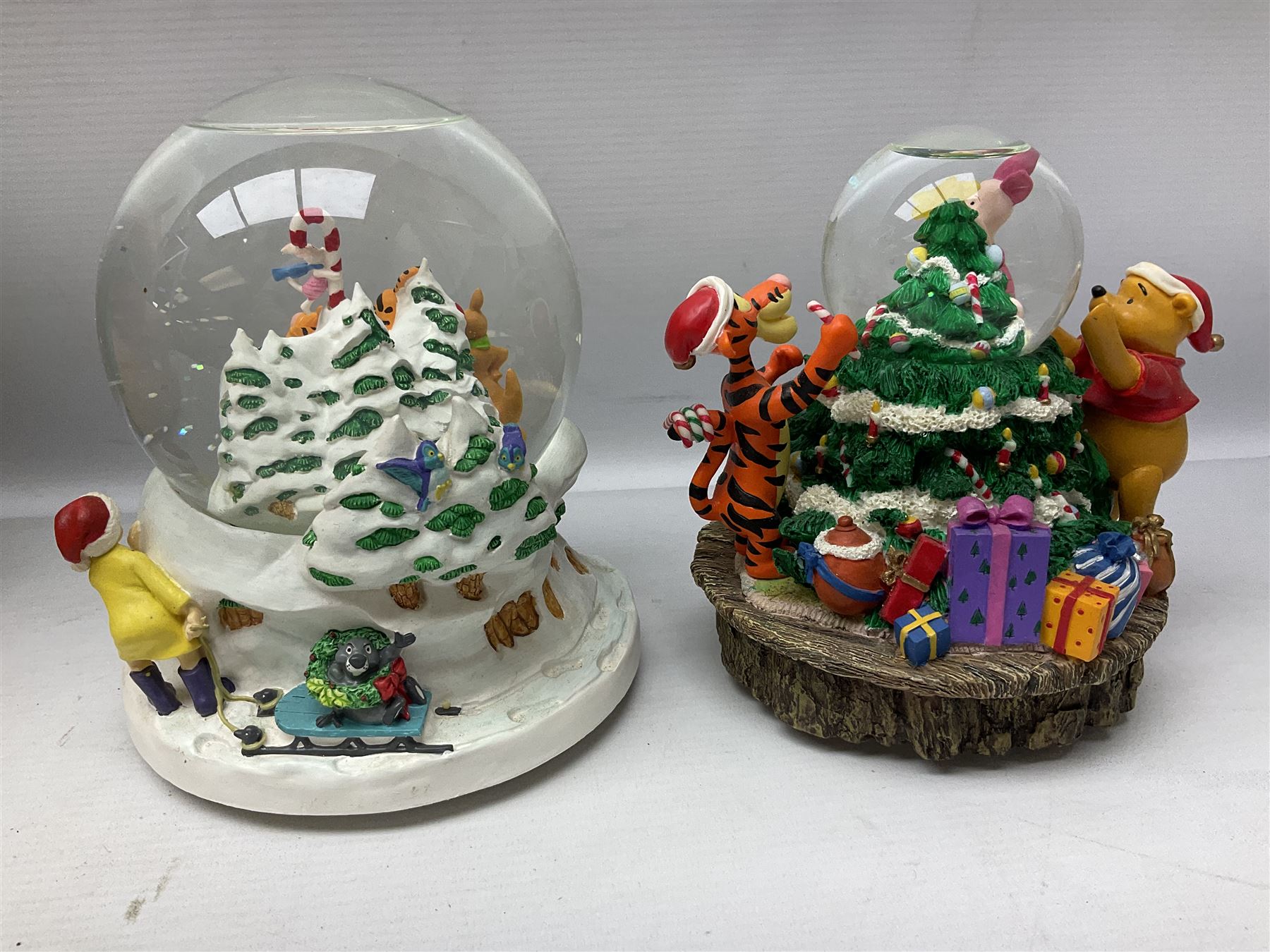 Six Disney Winnie the Pooh Christmas snow globes, comprising large Mr Christmas Holiday Snowfall, An Enchanted Christmas, It's A Small World Christmas 1994,  Tree Trimming, 1995 Christmas At Our House and Christmas Band Concert, together with Mr Christmas Holiday Go Round, all with boxes (7)