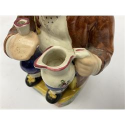 Mid 19th century pearlware Toby jug, modelled seated with a jug and pipe with spongeware decorated tricorn hat, raised upon a canted and sponged rectangular base, H24cm, together with another 19th century Toby Jug