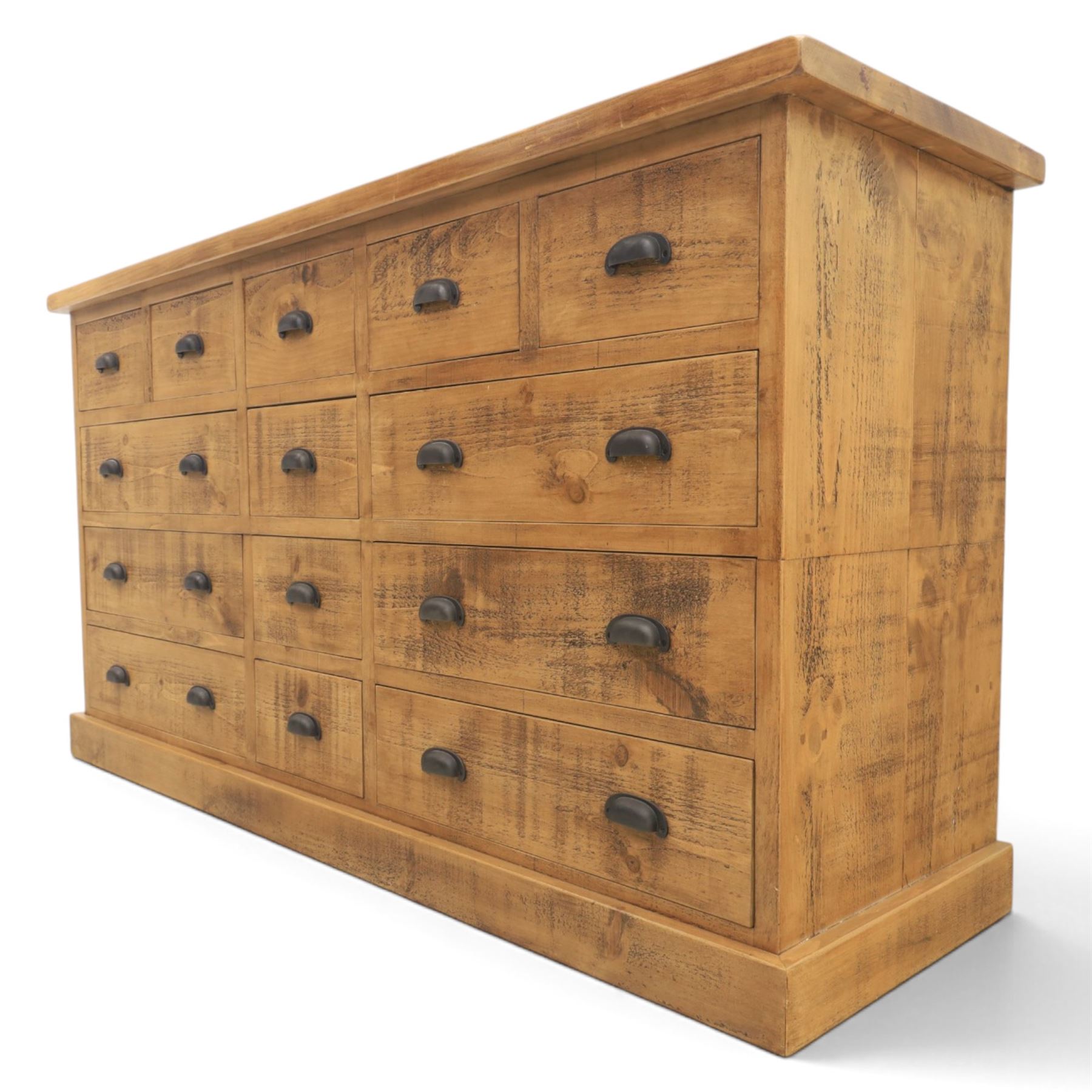 Indigo Furniture - large rustic oak combination chest sideboard, fourteen drawer with blackened metal cup handles, on a plinth base