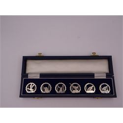 Set of six modern silver place card holders, each of circular form with pierced depictions of a partridge, spaniel, pheasant, stag, woodcock and duck, hallmarked J A Campbell, London 1985, contained within a velvet and silk lined fitted case, H3cm