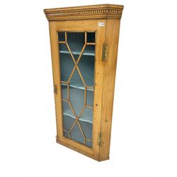Early 19th century pine corner cabinet, projecting dentil cornice over astragal glazed door