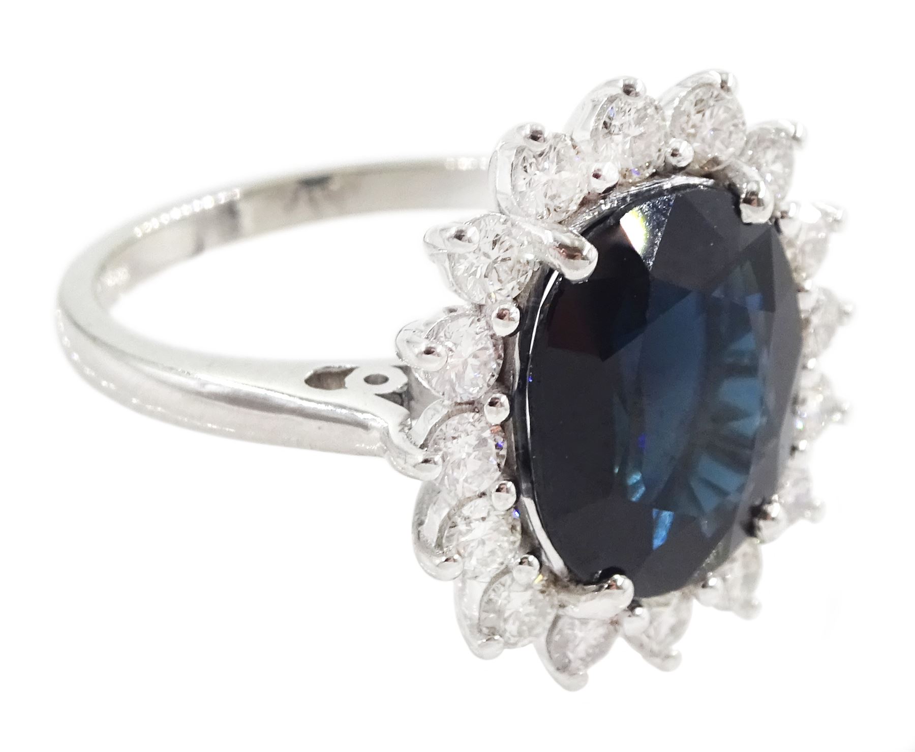 18ct white gold sapphire and diamond cluster ring, single oval cut sapphire of 4.33 carat, with round brilliant cut diamond surround, stamped 750, total diamond weight 0.72 carat