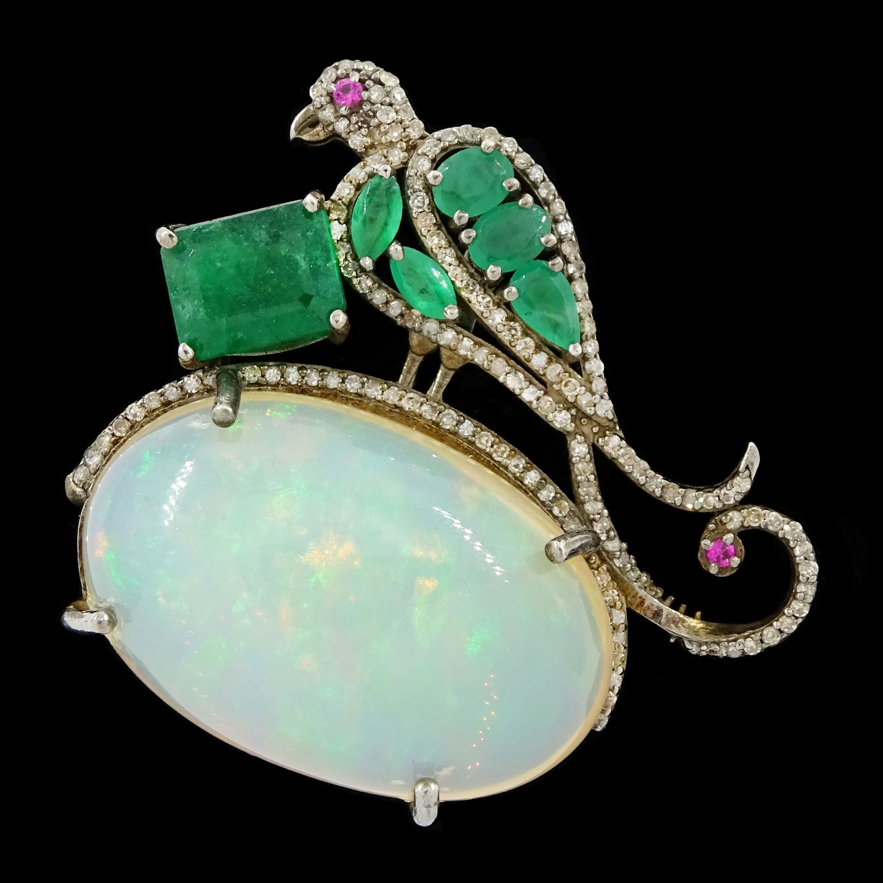 Silver opal, emerald, diamond and ruby bird pendant / brooch, emerald and diamond perched bird, on a single cabochon oval cut opal of approx 26.20 carat, total emerald weight approx 3.15 carat, total diamond weight approx 0.70 carat