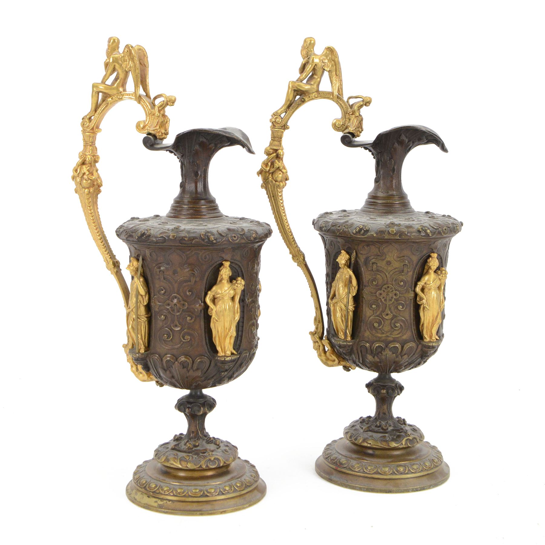 Pair of bronzed and gilt ewers in the Neo-Classical taste, each of typical form with figural detailed and mounted scroll handle surmounted by a winged figure, the bodies cast with scrolling strapwork, flower heads and acanthus leaves, and further detailed with applied gilt classical figures to oval recesses, upon a knopped stem and spreading circular foot with conforming cast detail, H28cm