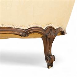 Late 19th century Victorian walnut button-back recamier, asymmetrical form, with cream damask fabric and gimp braid edging, shaped reeded apron above front and back scroll carved cabriole legs on brass castors