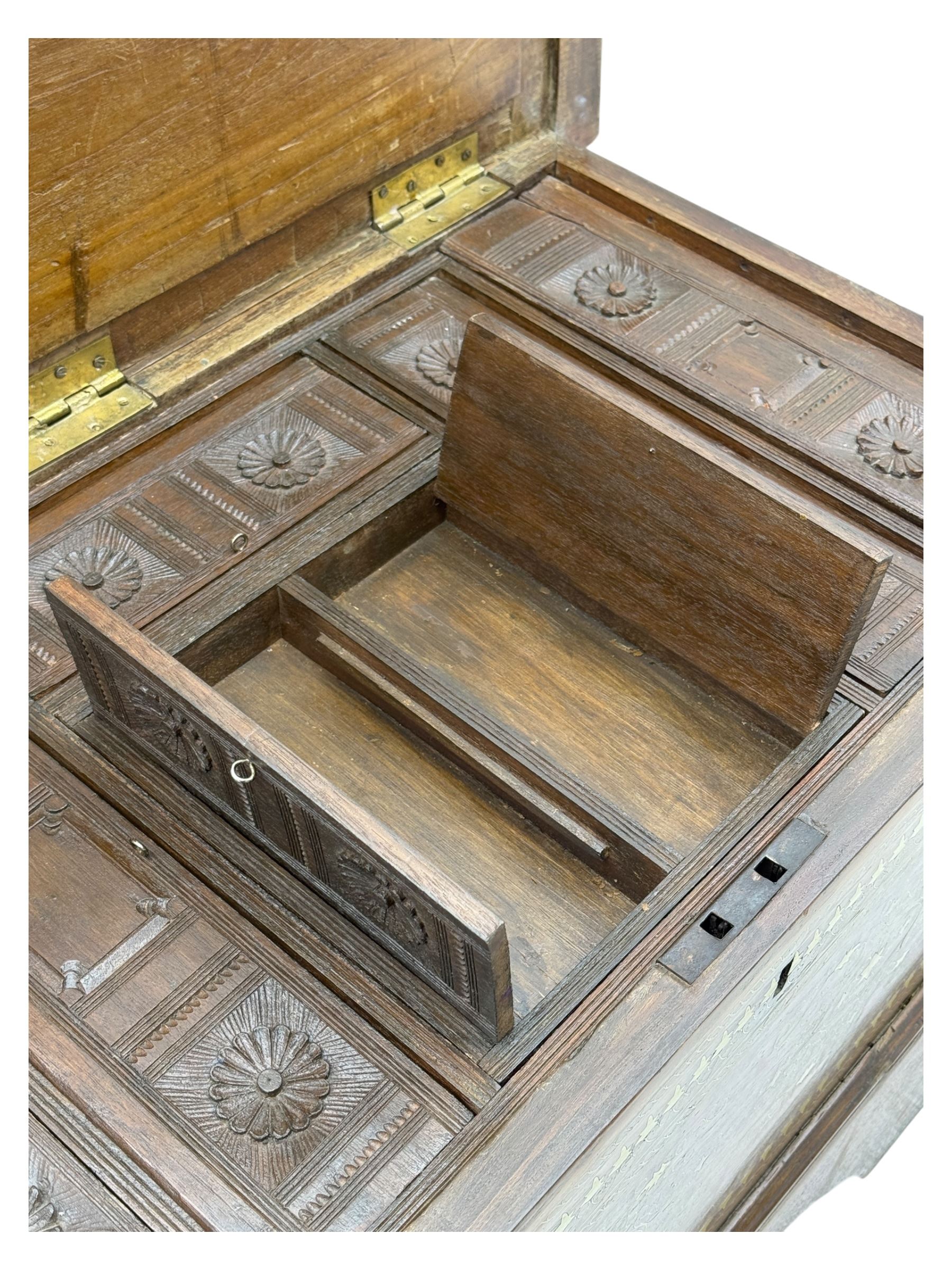 Zanzibar chest, early 20th century, of hardwood construction with brass inlaid foliate and geometric decoration to the lid, fitted interior of multiple carved compartments, with brass strapwork, side handles, and shaped bracket feet
