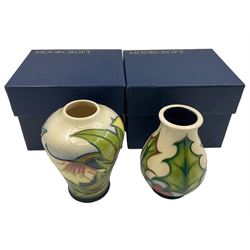 Two small Moorcroft vases, one decorated in the Ode to May pattern by Sian Leeper, circa 2005, H11cm and the other in the Holly and Berry pattern by Phillip Gibson, circa 2004, both signed by the artist with original boxes (2)