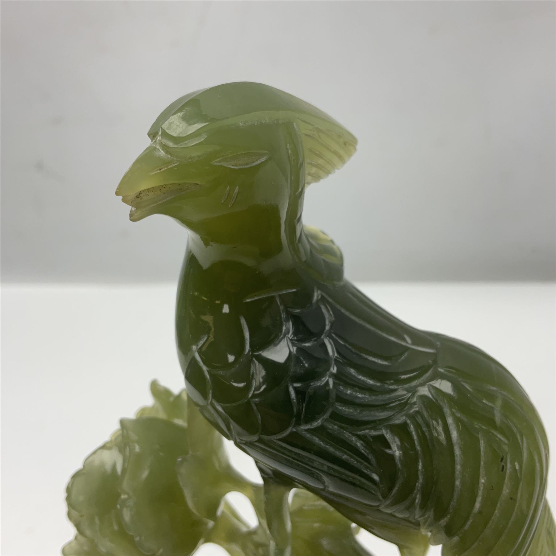 Carved jade figure of a phoenix perched on a flowering branch, upon a wooden stand, with original box, H27cm