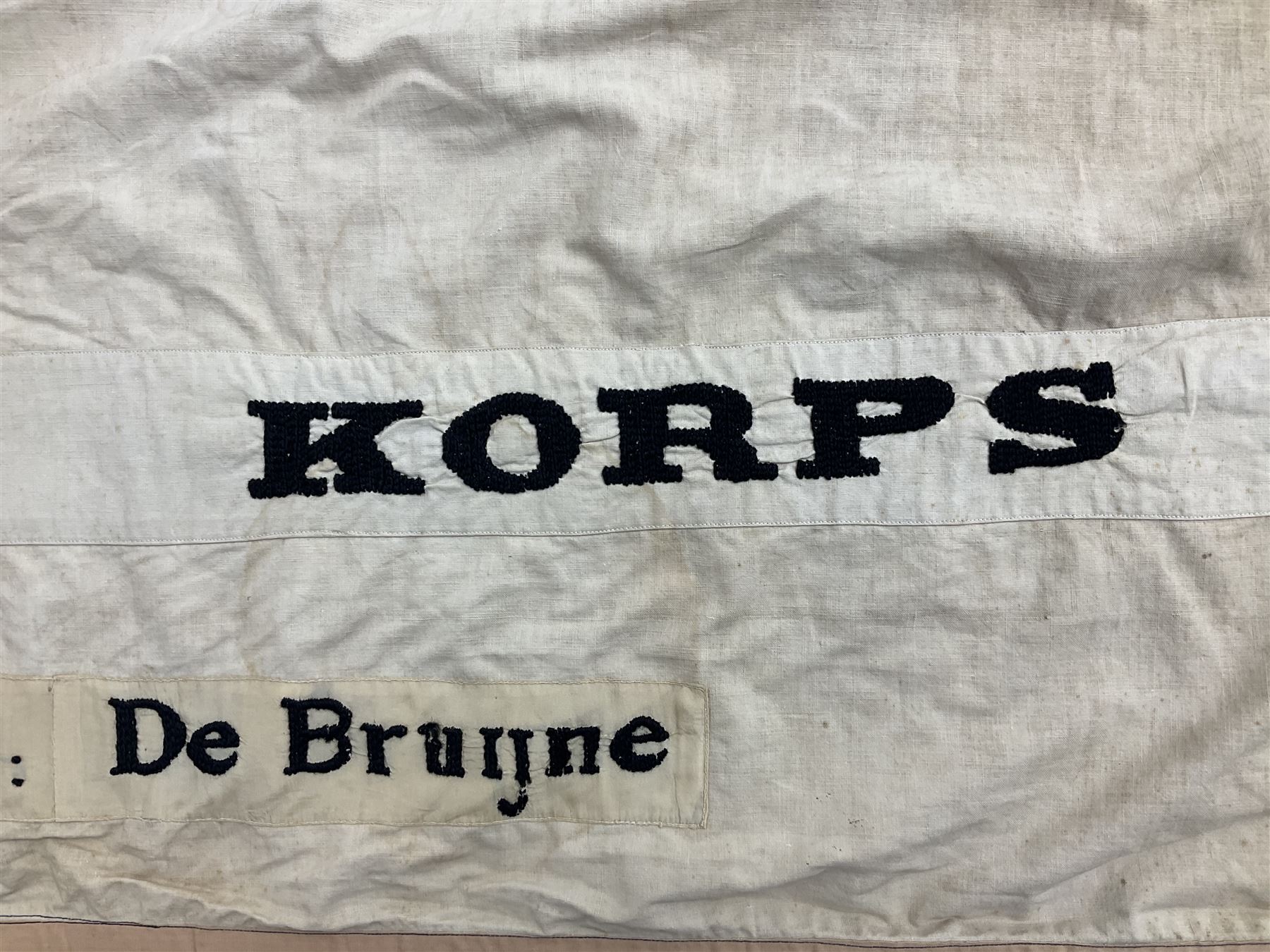 WW2 Belgian Partisan/Resistance two-sided banner embroidered in black on a cream ground 'Belgische Partisanen Korps 032 afd: Ph: De Bruyne' within a Belgian flag border; on wooden pole with gilded metal lion and laurel wreath finial