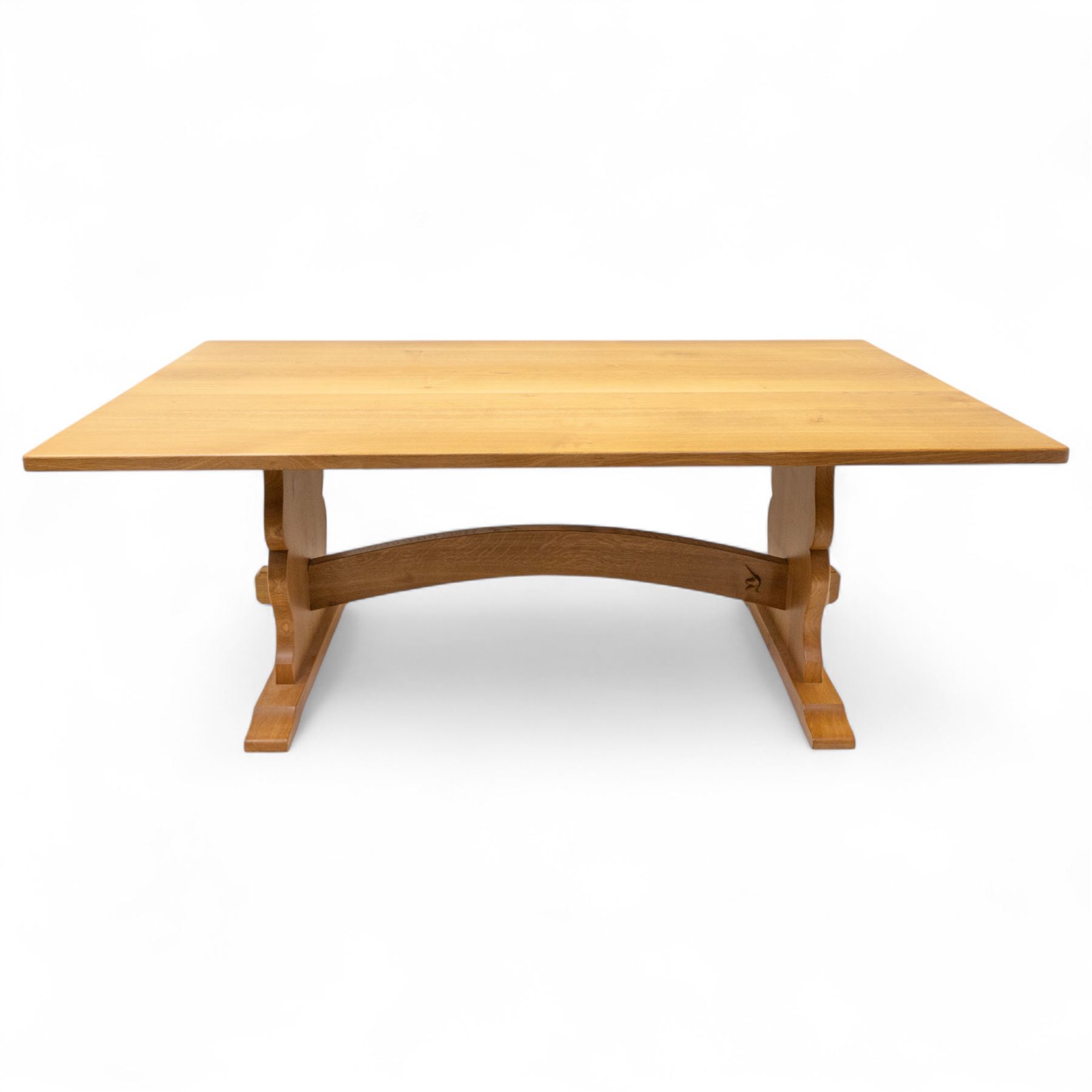 Unicornman - Yorkshire oak rectangular refectory style dining table by Coxwold cabinet maker Geoff Gell, rectangular top above trestle form base with broad scrolling outward outline, and heavy arched stretcher with Unicornman carved motif, traditional mortice and tenon pegged joints between the uprights