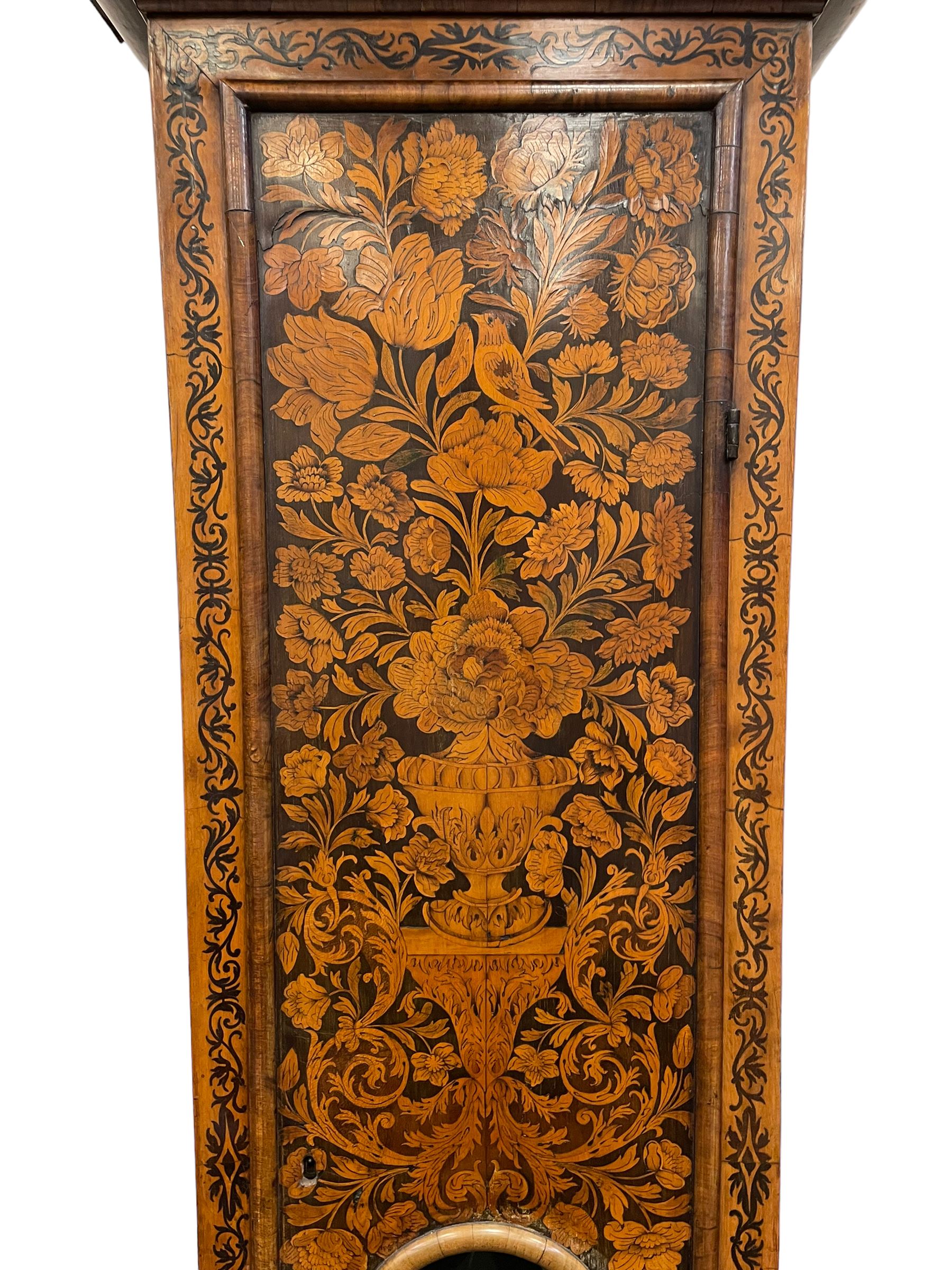 William & Mary floral marquetry 8-day longcase clock c 1700, later mid-18th century four pillar rack striking movement with a square brass dial and subsidiary seconds dial, ringed winding holes and calendar aperture to the matted dial centre, with London cherub head cast spandrels and (later) fretted steel hands, silvered Roman numeral chapter ring with stylised fleur di Lis half hour makers, narrow Arabic five-minutes, minute track and inner quarter hour track, signed Thomas Horlock, Hammersmith, 
case with box upstand to the domed floral marquetry decorated caddy with three brass flame finials, above a moulded cornice and fretwork frieze,  inlaid hood door with attached barley twist pillars to the front above an inlaid convex moulding, full length D moulded trunk door with a circular lenticle inlaid with floral and foliage panels inhabited with birds, on a conforming marquetry plinth with applied double skirting. Thomas Horlock is recorded as a Whitesmith & Clockmaker of Hammersmith, Middlesex.
A copy of Thomas Horlock's will dated the 15th June 1757 is held at The National  Archives Kew.