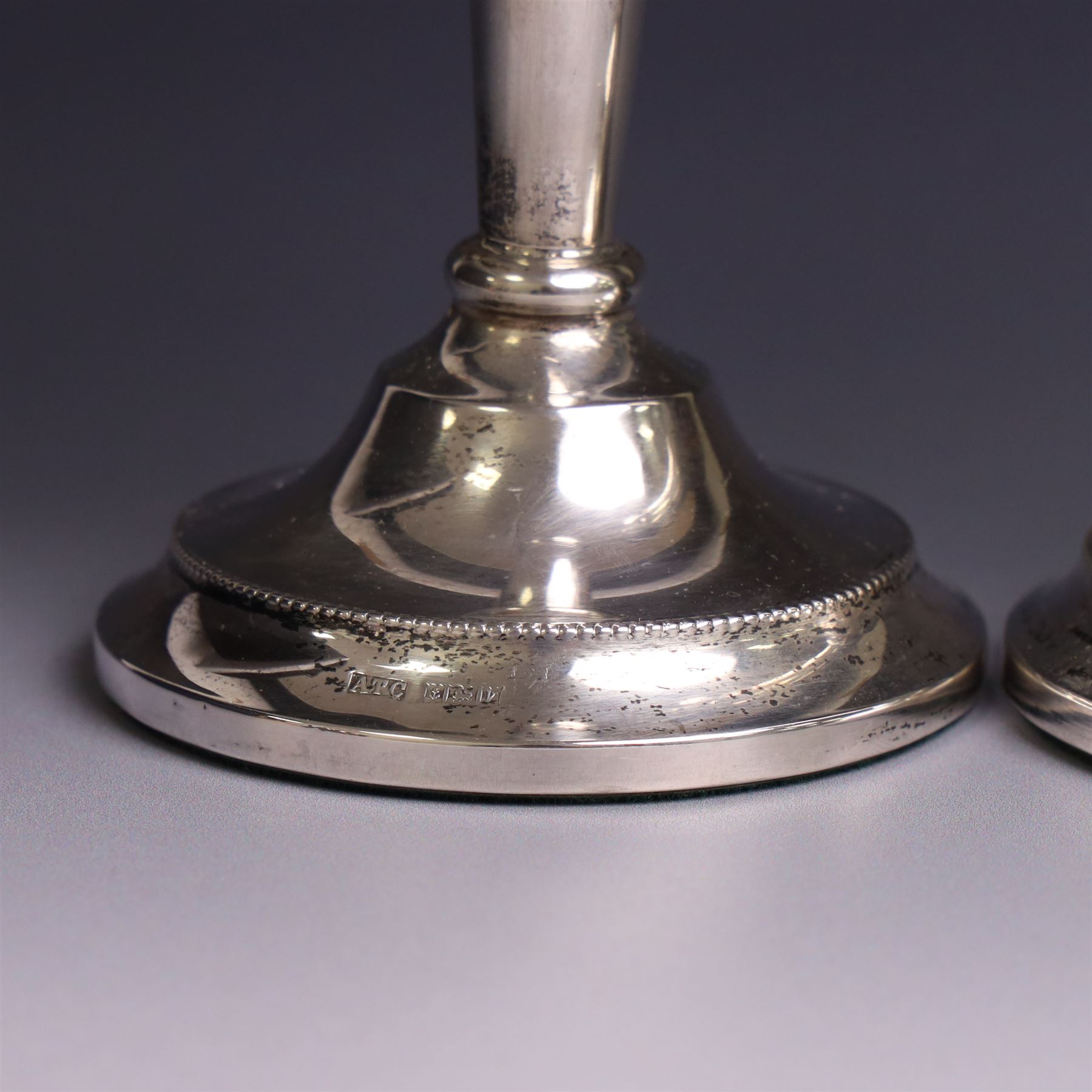 Pair of late 20th century silver candlesticks, each with tapering stem and upon circular beaded weigthed foot, hallmarked A T Cannon Ltd, Birmingham 1970, H21cm
