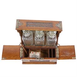 Victorian brass mounted oak tantalus, containing a set of three decanters, fitted with a games compendium to the front, H32cm