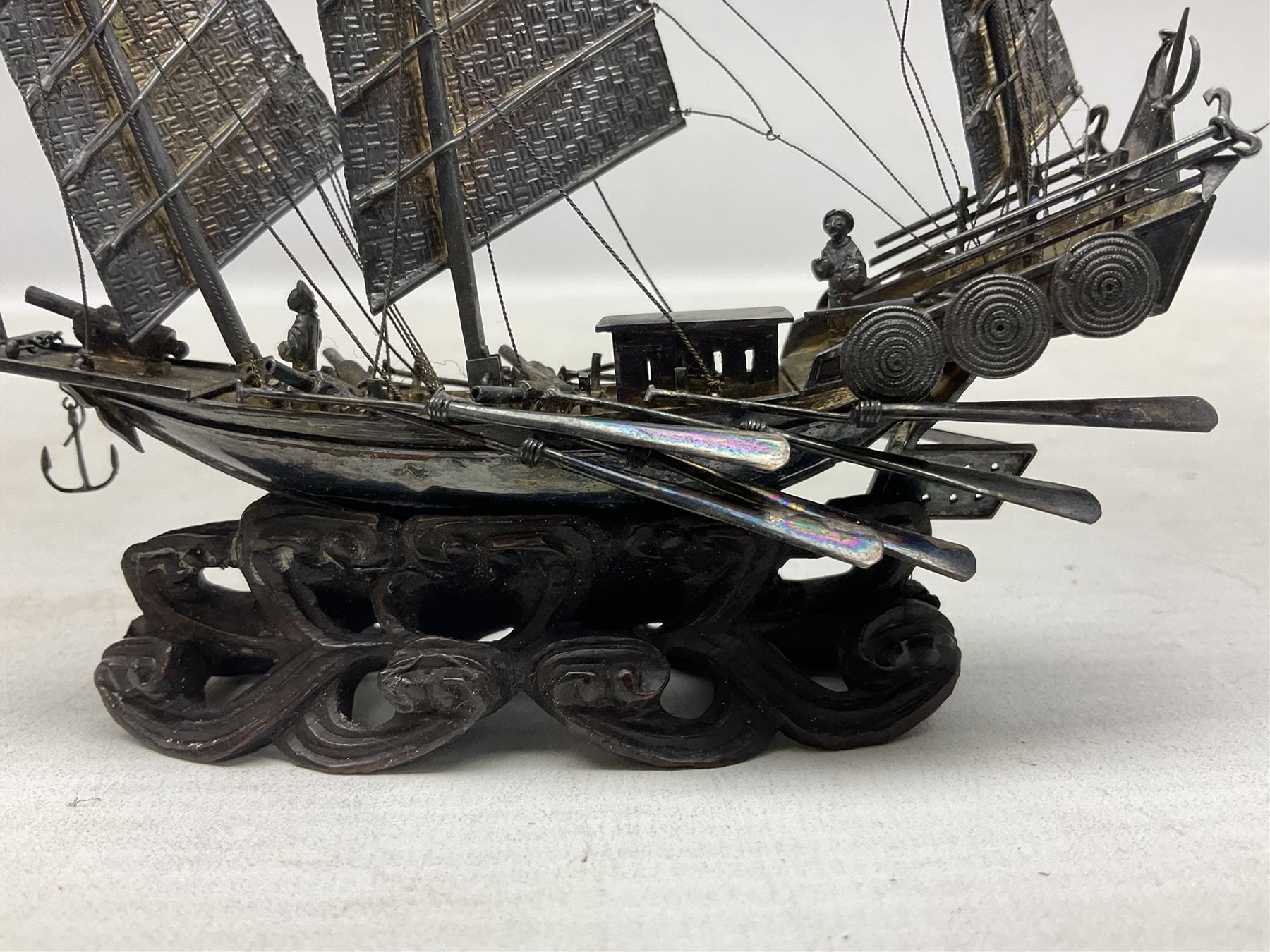 Chinese miniature silver model of a junk ship, with textured sails, mounted upon a carved wooden stand, H14cm