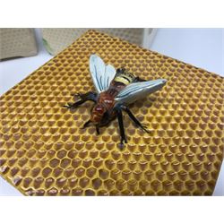 Four square honey boxes with lids,  each decorated with honeycomb pattern and finished with a bee finial