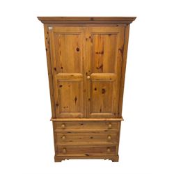 Solid waxed pine double wardrobe, two panelled doors enclosing hanging rail, base fitted with three drawers
