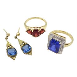 Gold three stone garnet ring and a gold synthetic blue stone dress ring, both hallmarked 9ct, and a pair of gilt stone set earrings