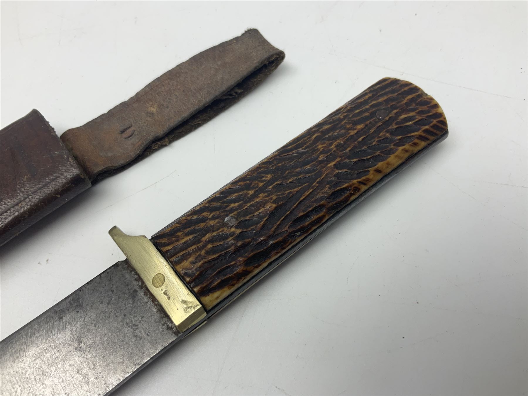 WW2 fighting knife, the 13cm blade by Priestman of Sheffield marked with scout and camp fire motif; two piece antler grip; in leather sheath crudely marked R.T. with a broad arrow L23cm overall Auctioneers Note: By family descent this knife was reputedly presented to Richard Towse during WW2 for guarding a group of POWs.