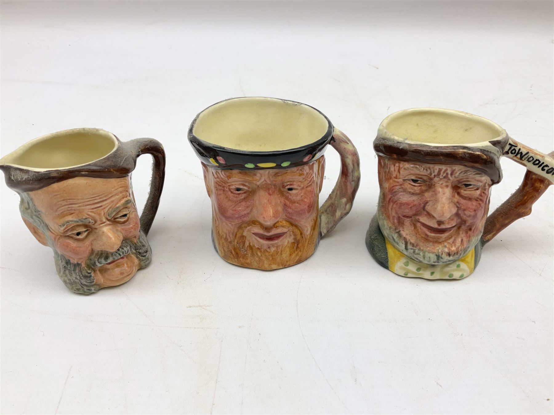 John Beswick figure of a seated piglet, Beswick Beatrix Potter Mrs Rabbit and Peter figure, and quantity of Sandland Character Ware jugs