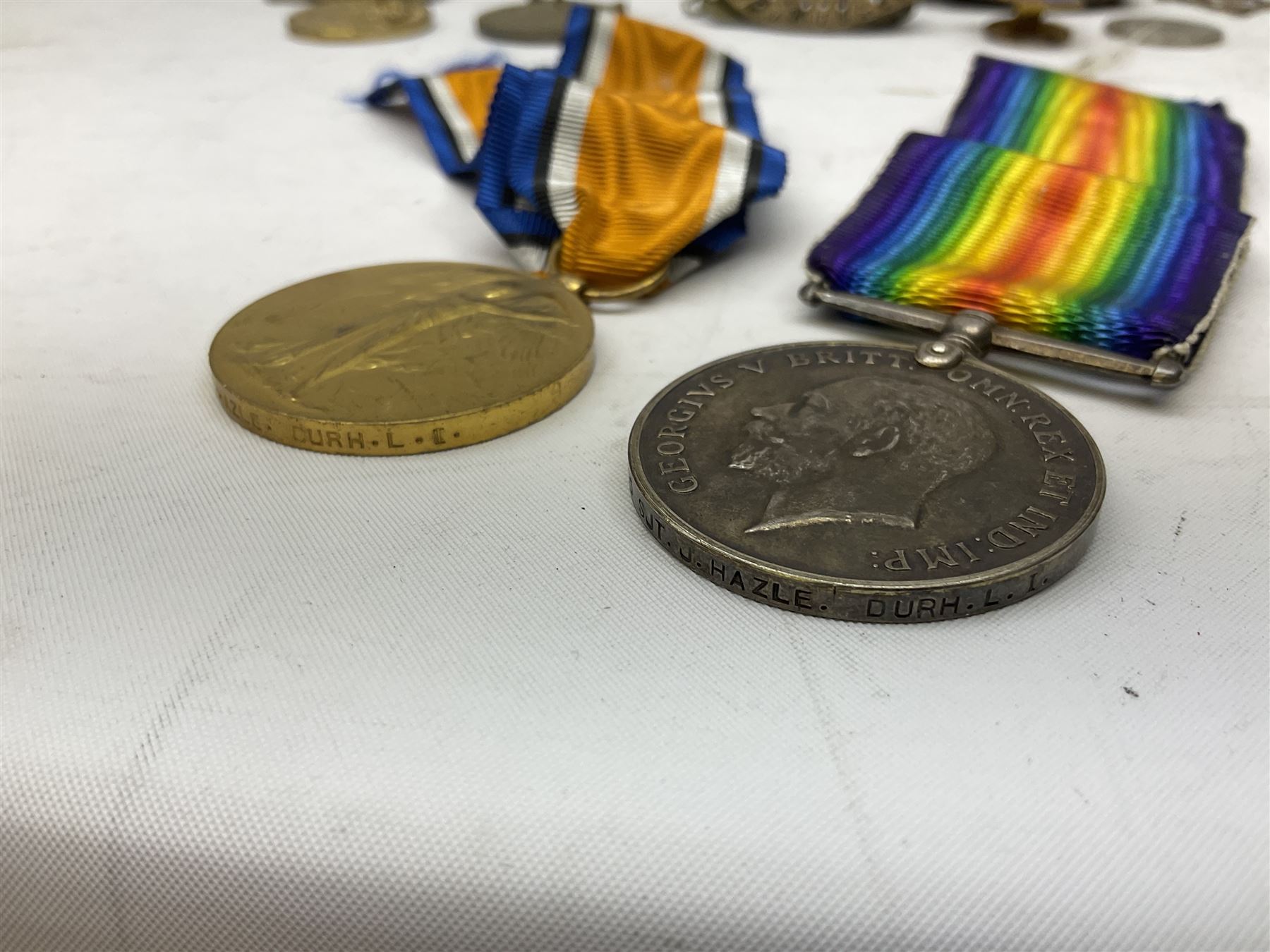 WW1 pair of medals comprising British War Medal and Victory Medal awarded to 24085 Sjt. J. Hazle Durh. L.I.; together with Durham Light Infantry cap and collar badges, shoulder titles, buttons etc; various royalty commemorative medallions etc