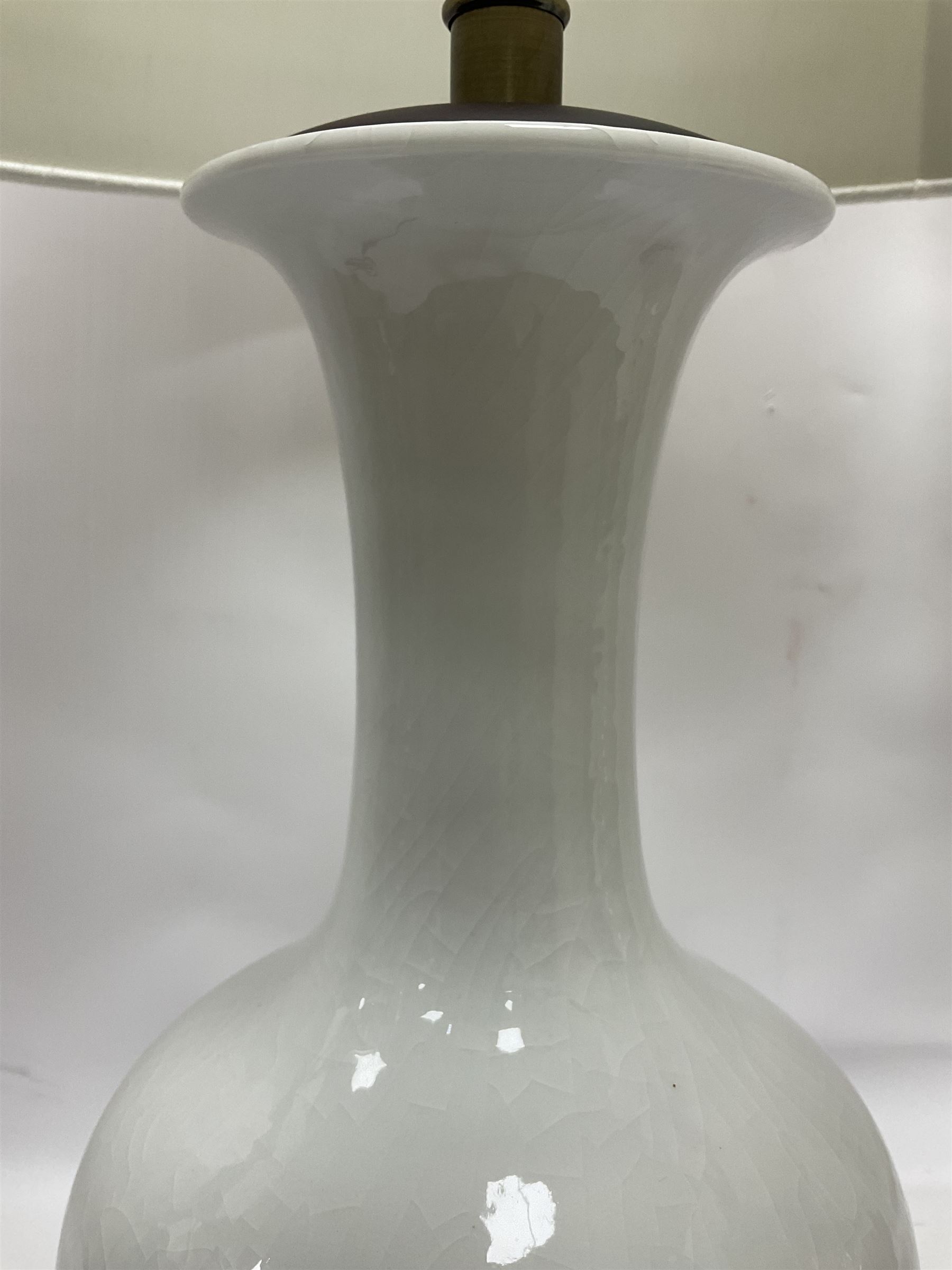 Pair of Chinese ivory crackle glazed table lamps, each of bottle form, raised upon circular hardwood base, excluding fittings H43cm