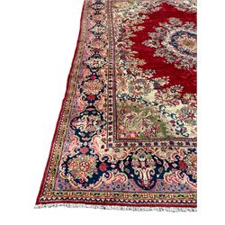 Persian Mahal crimson ground carpet, the plain field with floral spandrels and a foliate bordered central medallion, the indigo guarded border with repeating plant motifs and scrolling