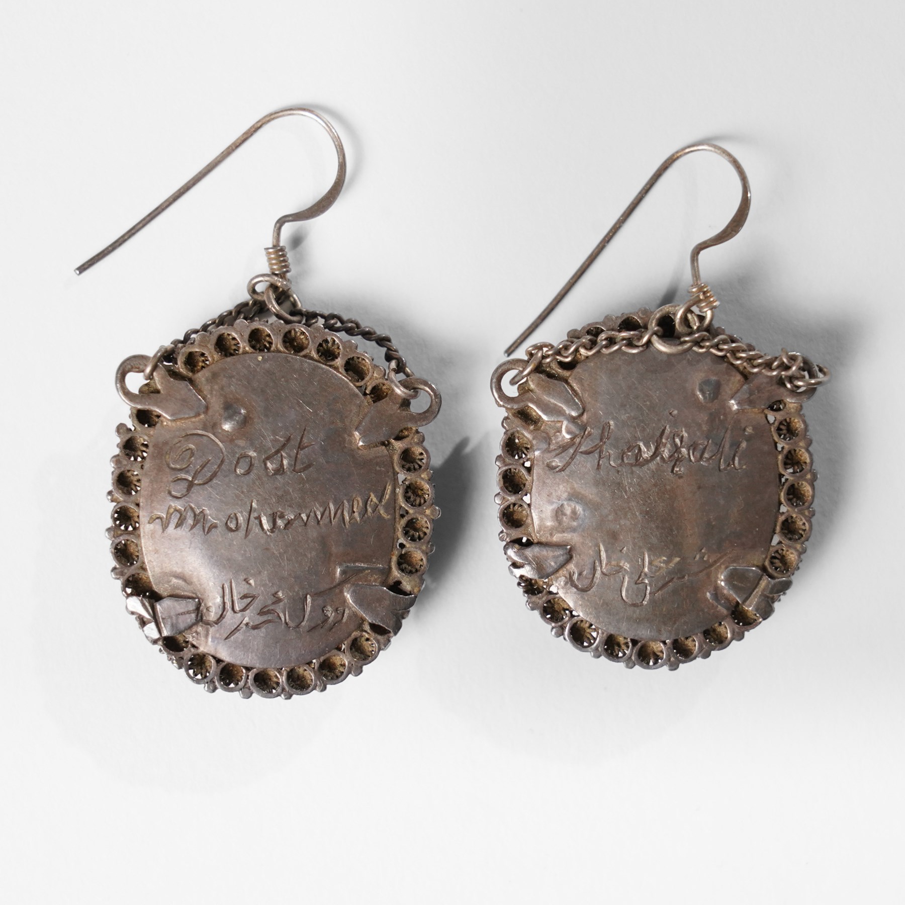 Northern Indian/Company School (19th Century): Emir Dost Mohammad Khan and his son Sher Ali Khan, pair of portrait miniature earrings on ivory, mounted in silver with filigree borders, likely commissioned during the period of British diplomatic engagement in Afghanistan (c.1860-1880), inscribed verso, each miniature approx. H2cm This item has been registered for sale under Section 10 of the APHA Ivory Act