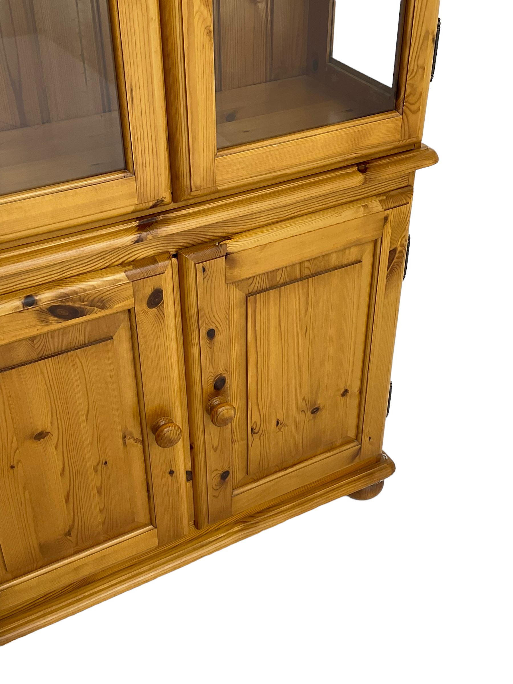 Pine display enclosed by glazed doors, fitted with three