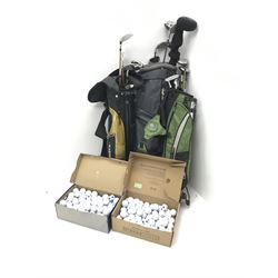 Three bags of golf clubs and two boxes of golf balls