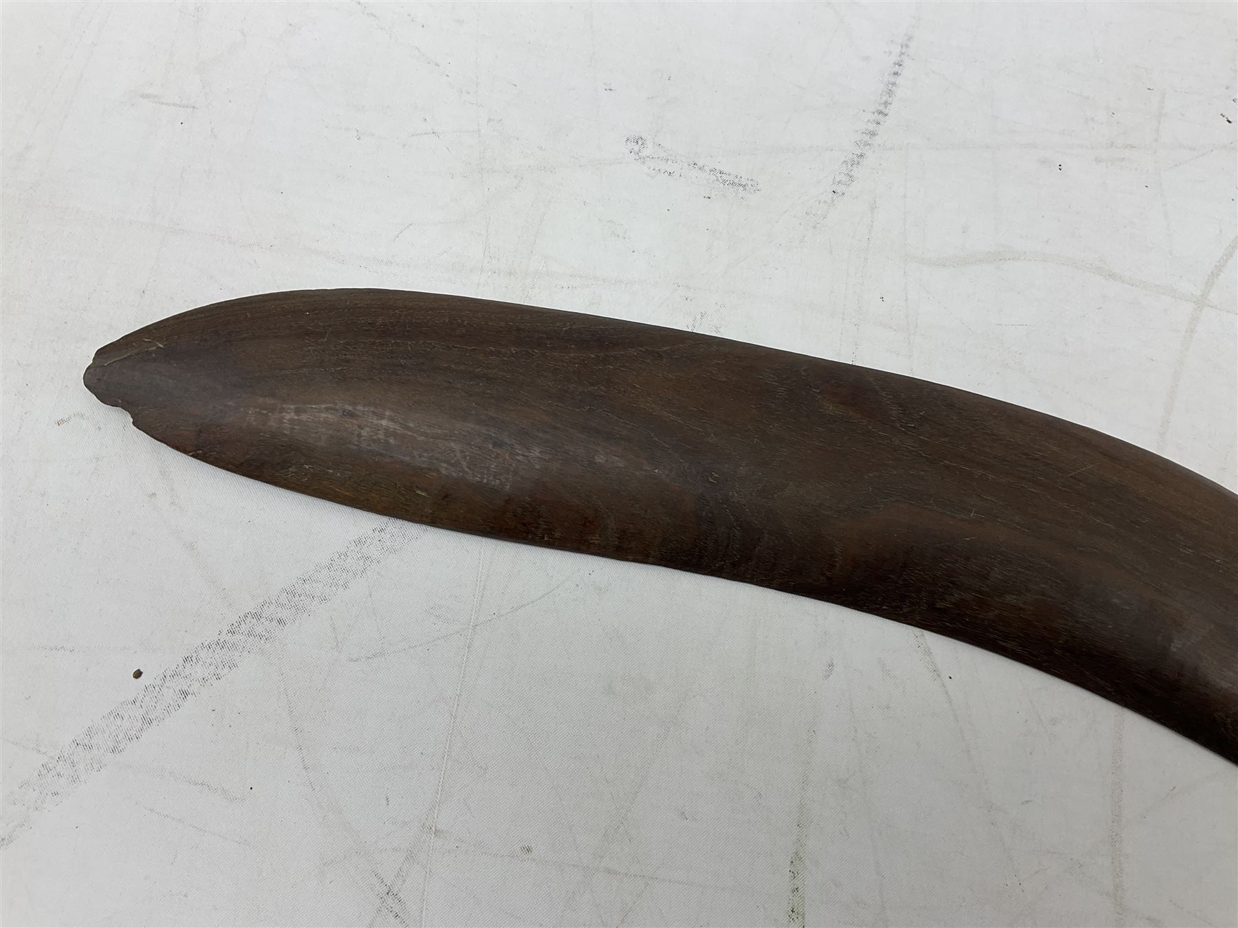 Australian aboriginal woomera spear thrower incised/carved with a wavy line and dots L69cm; and two boomerangs, one with carved geometric decoration (3)