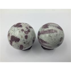 Pair of pink tourmaline spheres, upon carved wooden bases, D5cm