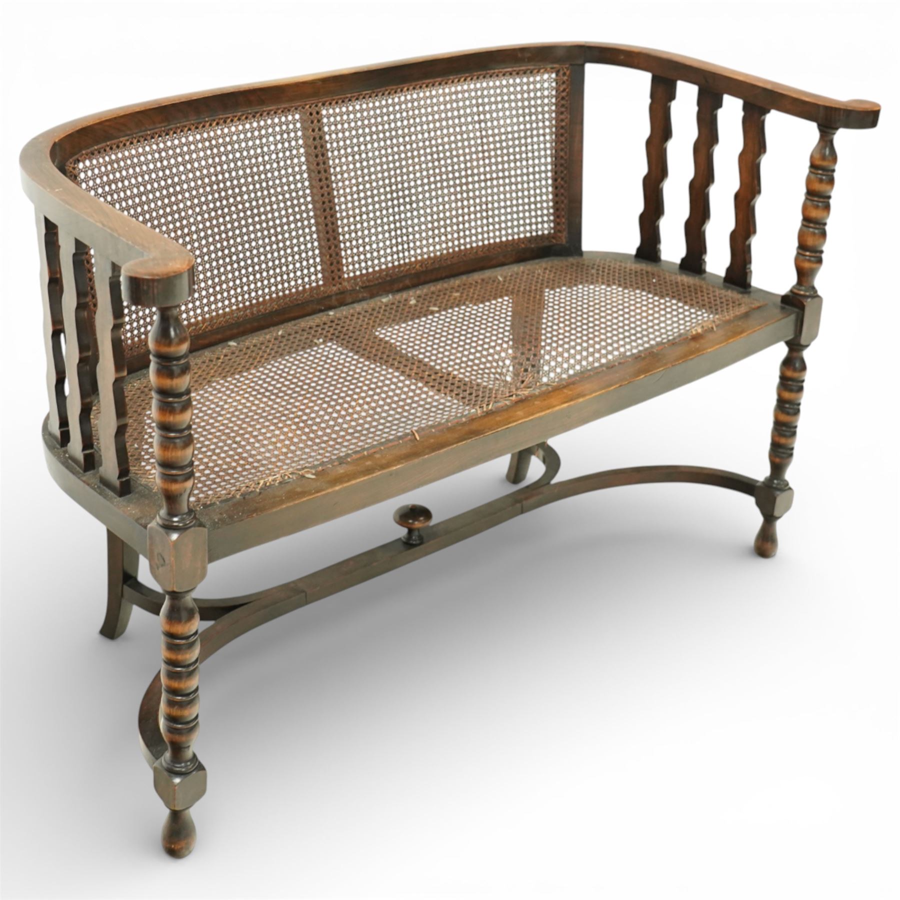 20th century bergère two seater settee, with shaped curved top rail and downswept arms, the back and seat fitted with woven cane panels, supported by turned uprights and legs united by a carolean stretcher 