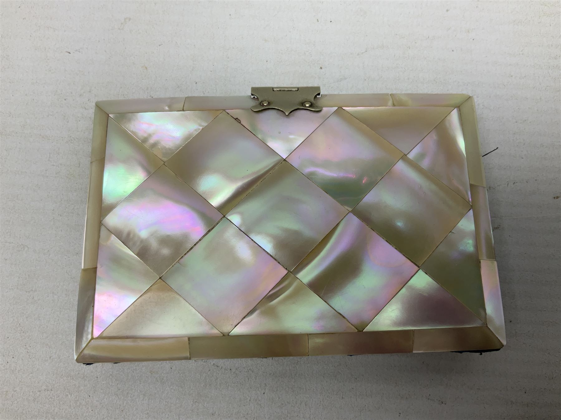 Mother of pearl and abalone inlaid card case, with central diamond shaped panel engraved with foliate decoration, together with a simulated mother of pearl card case of book form with green sun rays to cover, and simulated wood effect cigarette case with hinged lid with diamante style banding, largest L10cm