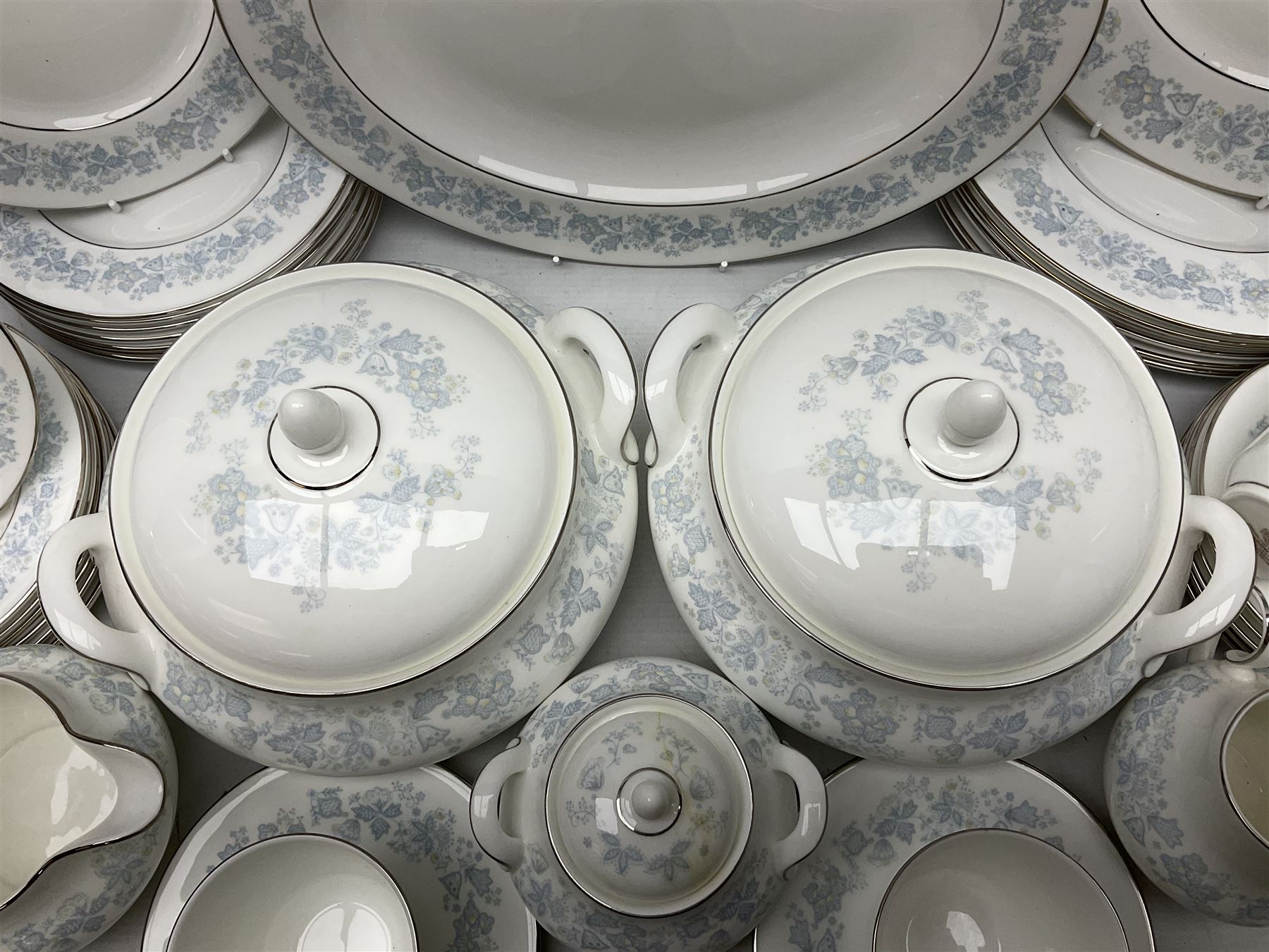 Royal Doulton tea and dinner wares in the Meadow Mist pattern, no H5007, comprising seven dinner plates, eight side plates, two lidded tureens, two jugs, lidded sucrier, oval serving dish, six teacups, seven saucers, seven tea plates and large saucer