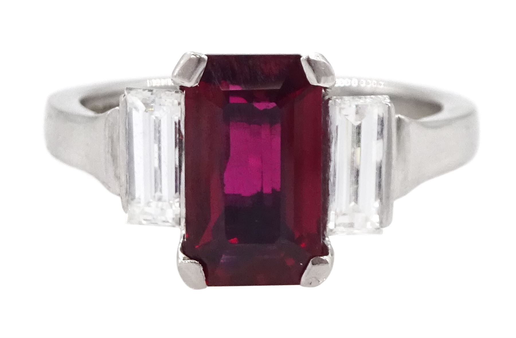 18ct white gold ruby and diamond three stone ring, single emerald cut Thai ruby of approx 2.00 carat, with a baguette cut diamond set either side, hallmarked, total diamond weight approx 0.60 carat