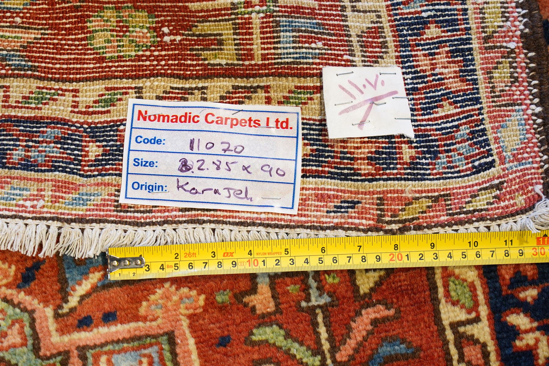 North West Persian Karajeh hand-knotted runner, field decorted with a series of linked stepped hexagonal medallions encloing stylized geometric motifs, surround by angular floral and tribal devices on a terracotta red ground enclosed a navy main border of repeating geometric and rosette motifs, between multiple guard stripes, with cotton fringe ends 