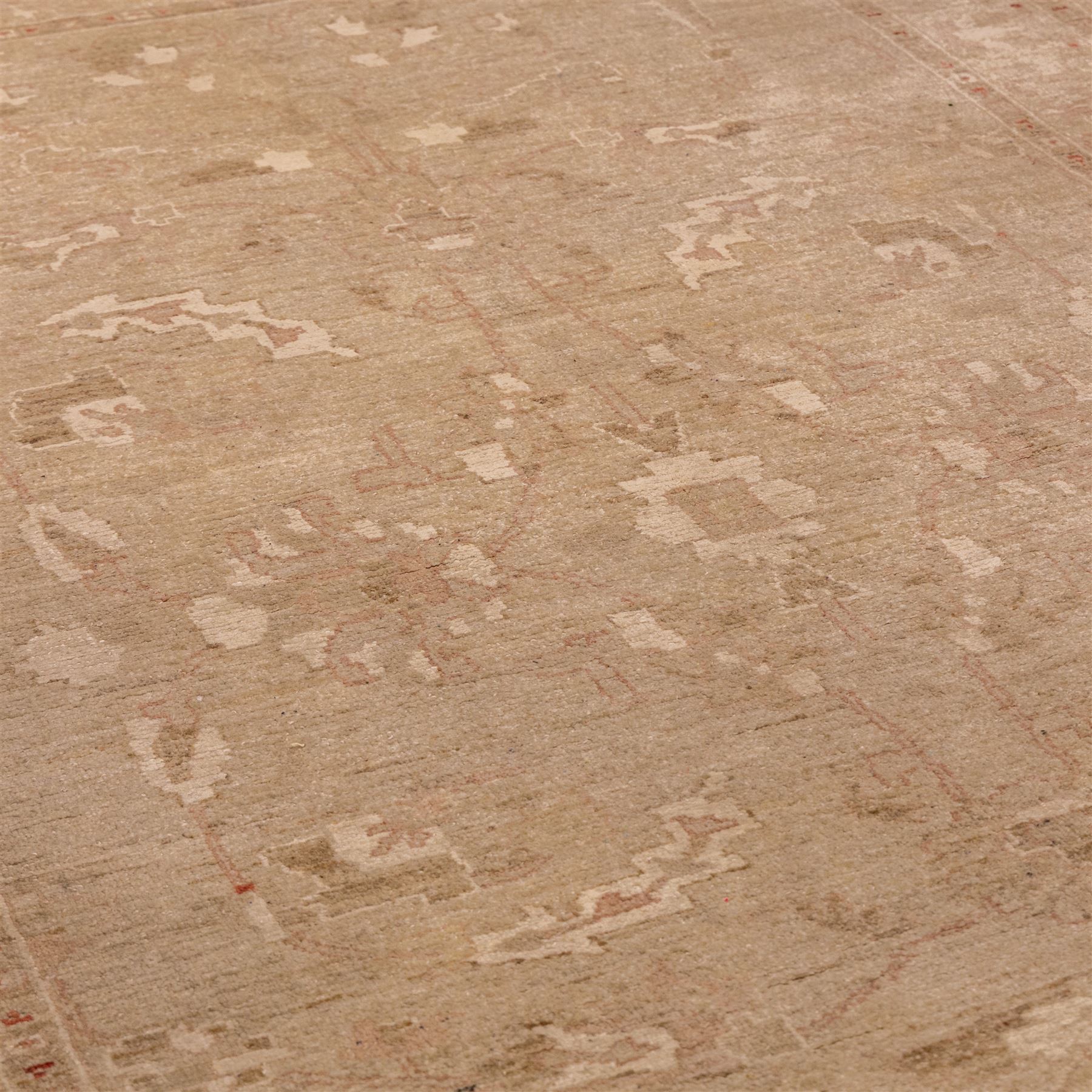 Afghan Ziegler hand-knotted carpet, soft ivory field woven with an elegant arrangement of scrolling vines and stylized palmettes with a central medallion, palette in muted tones of beige, terracotta, and blush pink, within a broad complementary border of angular floral devices and reciprocal guard stripes, fringe ends