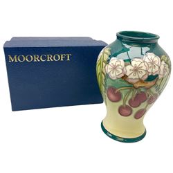 Moorcroft vase, of baluster form, decorated in the Cherries pattern designed by DJ Hancock, with impressed and painted marks beneath, including date symbol for 1999, H15.5cm, with maker's box. 