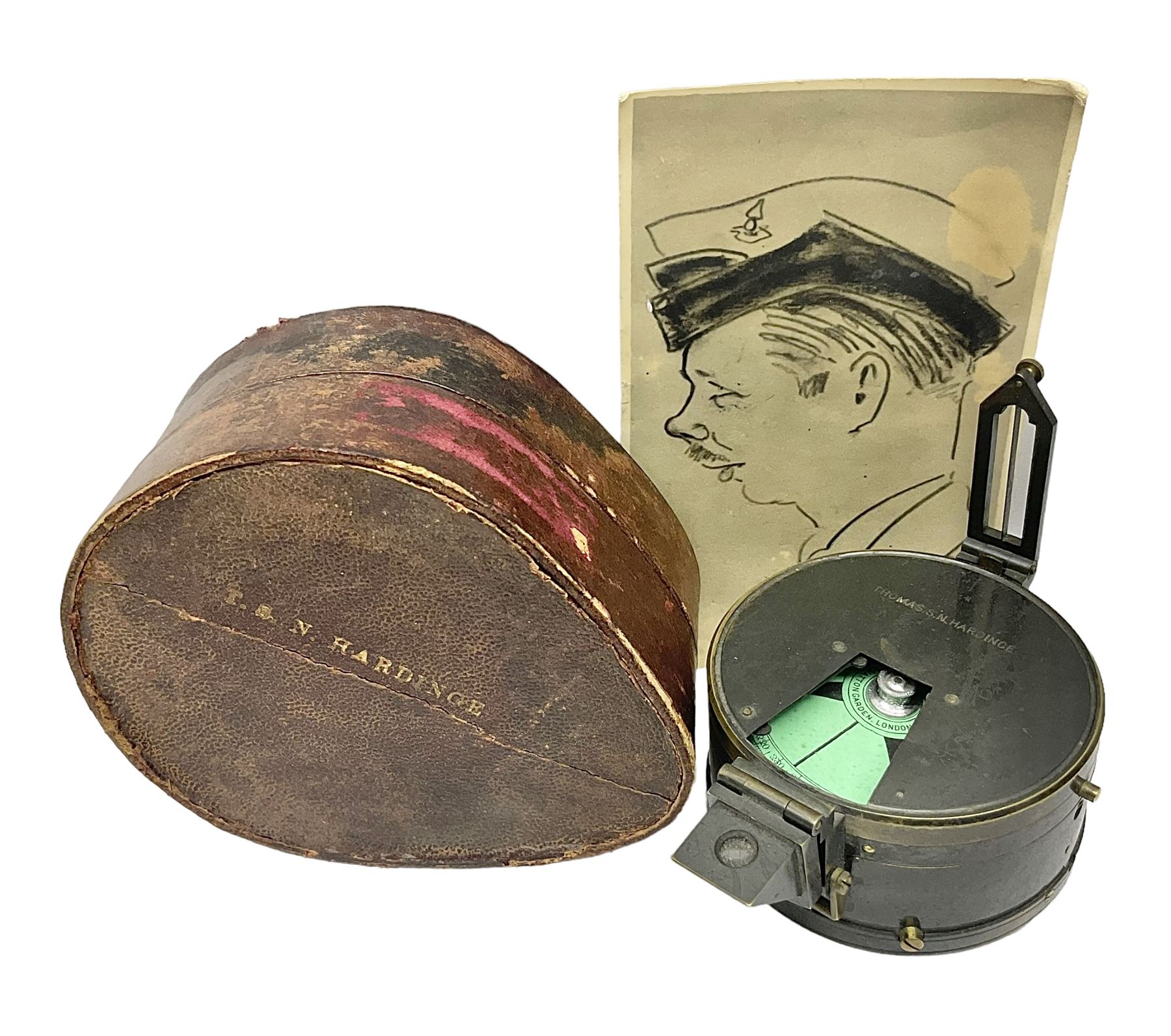 19th century Watkins combined clinometer and compass, patent 217, by J. Hicks Maker 8 Hatton Garden London No.5829, of drum shaped form in lacquered brass case D7cm; both instrument and case bear the name of former owner Thomas S.N. Hardinge; with early 20th century postcard caricature of a serviceman (2)