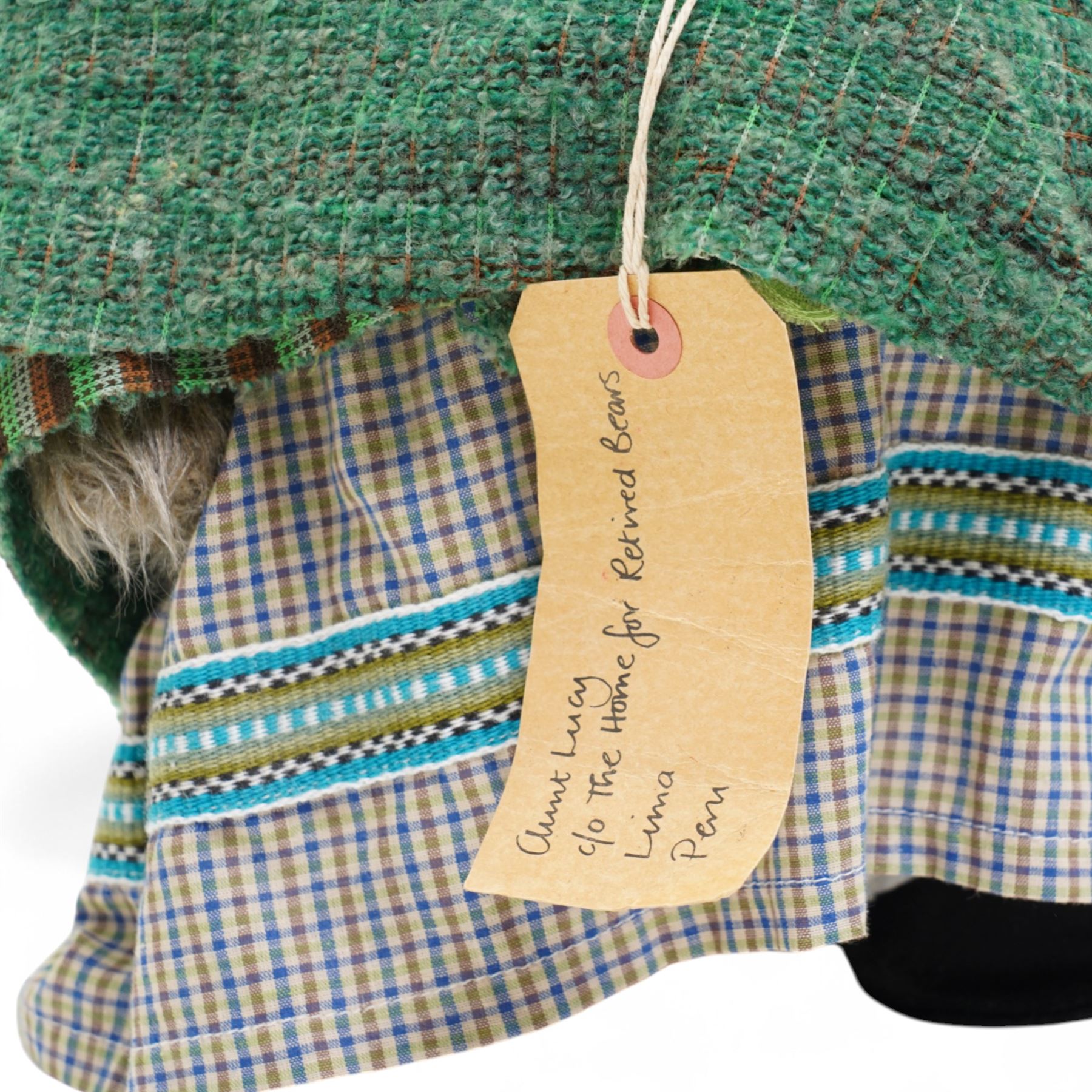 Gabrielle Designs Paddington Bear 'Aunt Lucy', 1978, dressed in green shawl, with hat and spectacles, tartan dress and luggage tag from the Peruvian Rugby FC Reserves Supporters Club, H50cm