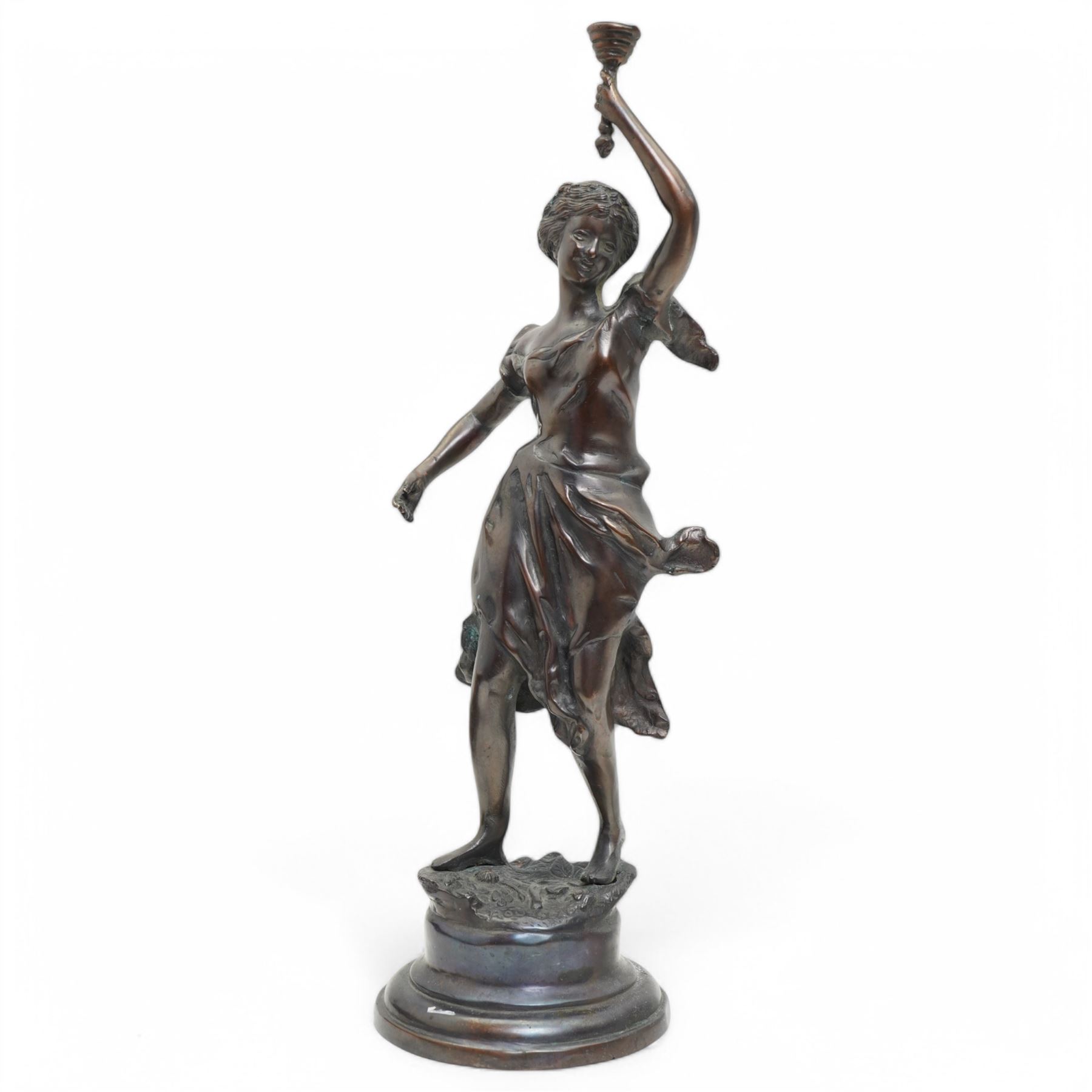 After Victor Rousseau (1865-1954)  - bronze sculpture of a lady holding aloft a torch and on circular base H50cm