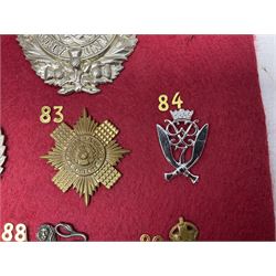 Twenty-two glengarry and cap badges including Argyll & Sutherland, Devonshire, Essex, Hampshire, Royal Berkshire, Northamptonshire, Long Range Desert Group, Royal Corps of Signals, Norfolk, Dorsetshire, East Lancashire etc; mounted on a board for display
